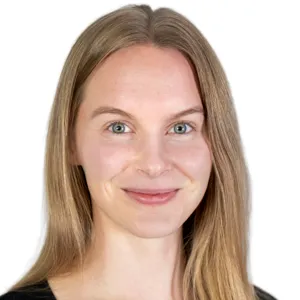 En kvinna med långt blont hår som ler mot kameran.