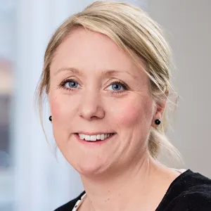 Person som sitter vid ett konferensbord med en dator framför sig